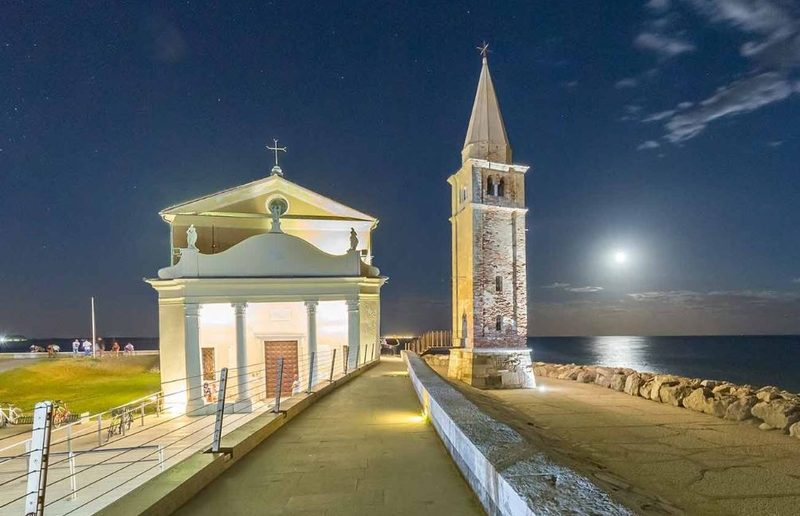 Santuario della Madonna dell'Angelo e campanile illuminati di notte con la luna piena
